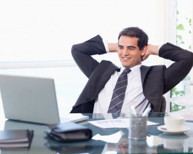 Relaxed businessman working with a laptop in his office