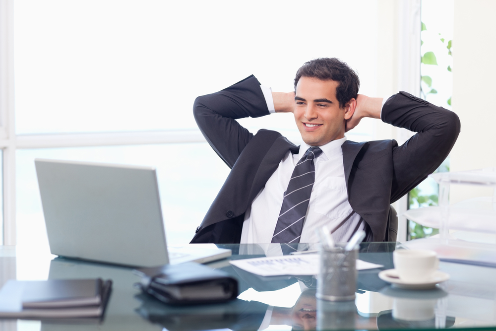 Relaxed businessman working with a laptop in his office